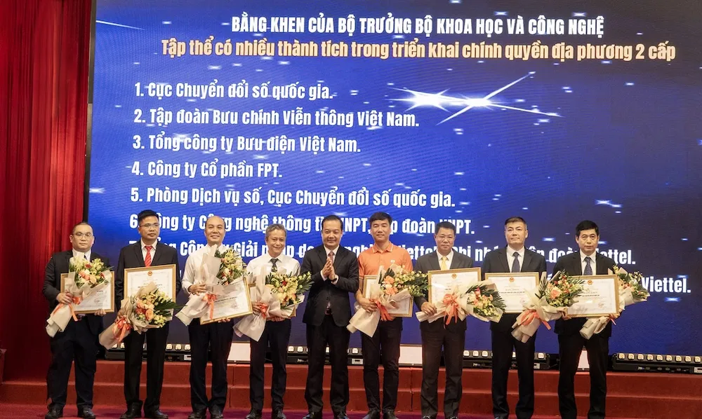 Đại diện FPT (áo cam) nhận bằng khen của Bộ KH-CN.